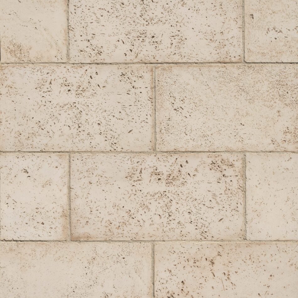 Close-up of symmetrically placed off-white stone veneer blocks with dark specks.