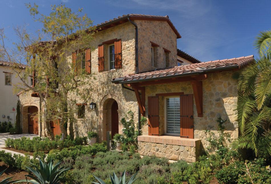 This house features masonry veneer from Creative Mines. There are various trees and green plants incorporated throughout the landscaping.