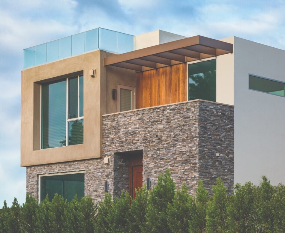 A two story modern home with ledge stones, smooth plaster and wooden accents.