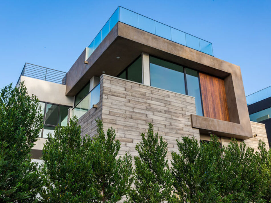 A worms-eye-view of a modern home made of wood veneers, concrete and glass.